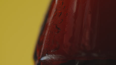 Close-Up-Of-Condensation-Droplets-Running-Down-Bottle-Of-Cold-Beer-Or-Soft-Drink-Against-Yellow-Background